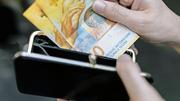 Eine Person entnimmt eine Zehnernote aus ihrem Portemonnaie, aufgenommen am 18. Oktober 2017 in Zuerich.