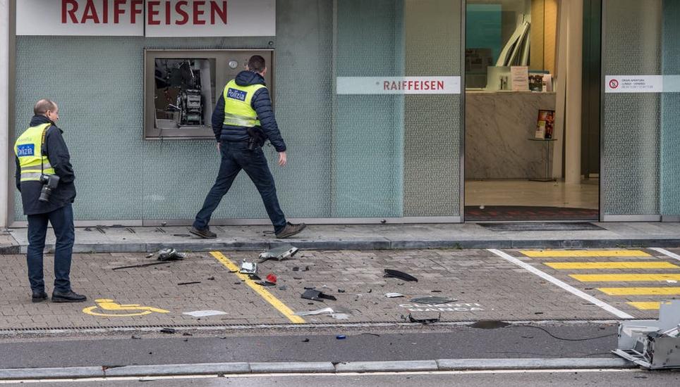 Bandengewalt, die sich schon heute bei in Dörfern und Städten zeigt: Polizisten stehen vor einem gesprengten Bancomat einer Raiffeisen-Bank. Keystone / KEYSTONE/TI-PRESS