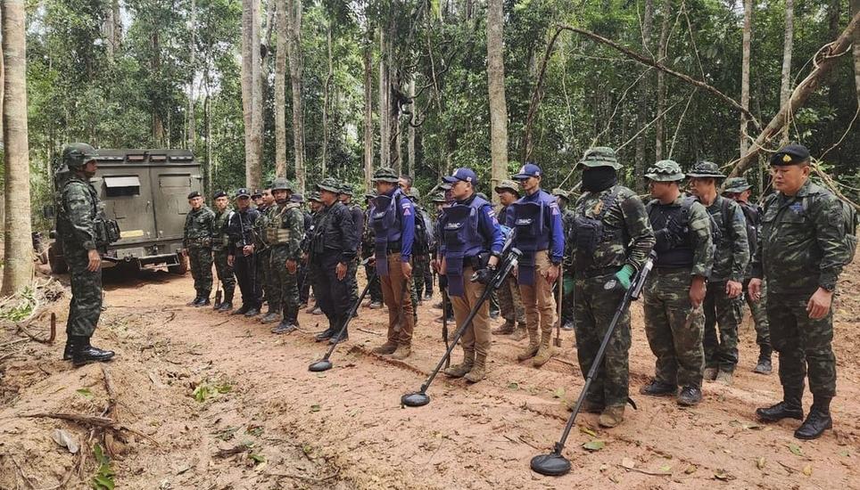 Thailändische Truppen mit Minensuchgeräten in der Nähe der Grenze. Bild: Keystone