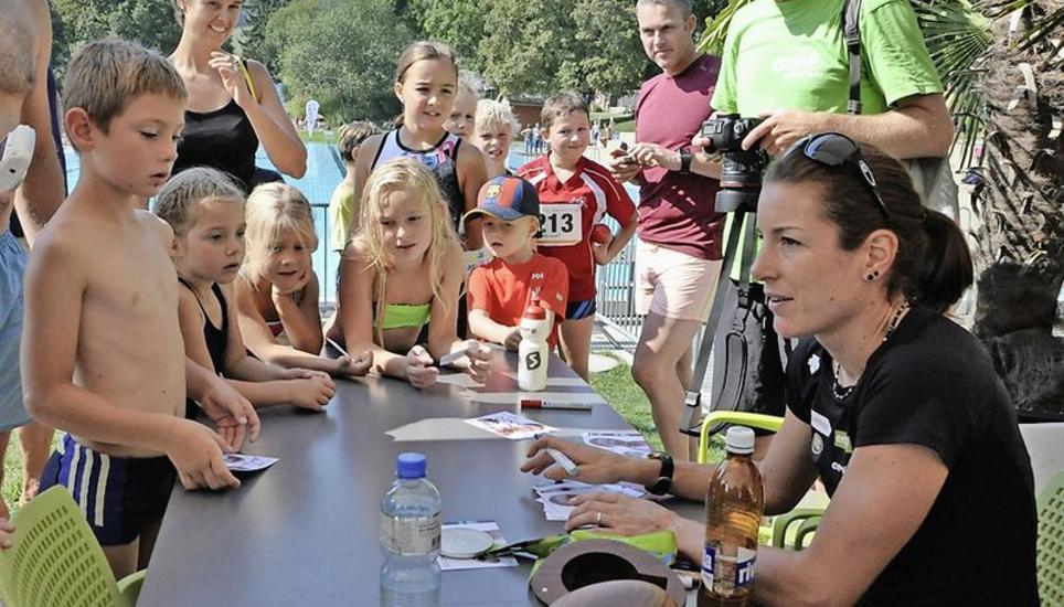 Begehrte Autogramme: Nicola Spirig (r.) setzte ihre Unterschrift auf T-Shirts, Startnummern, Mützen und Karten. Power-Kids-Triathlon, Nicola Spirig, Olympiasiegerin,