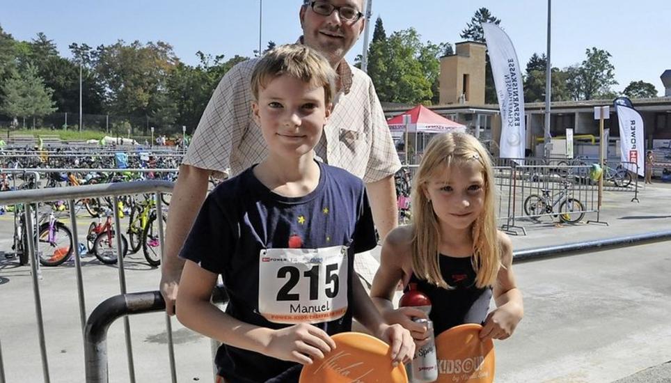 Support durch den Vater: Daniel Grütter (hinten) unterstützte seine Kinder Manuel (l.) und Mirella auf moralischer Ebene. Power-Kids-Triathlon, Nicola Spirig, Olympiasiegerin,