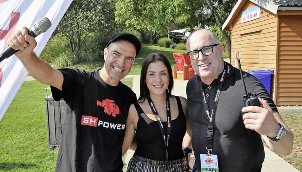 Organisatoren beim Start: Ralph Aichem, Naemi Solla und Silvio Grossi (v. l.) mit Mikrofon und Funkgerät als Arbeitsutensilien. Power-Kids-Triathlon, Nicola Spirig, Olympiasiegerin,