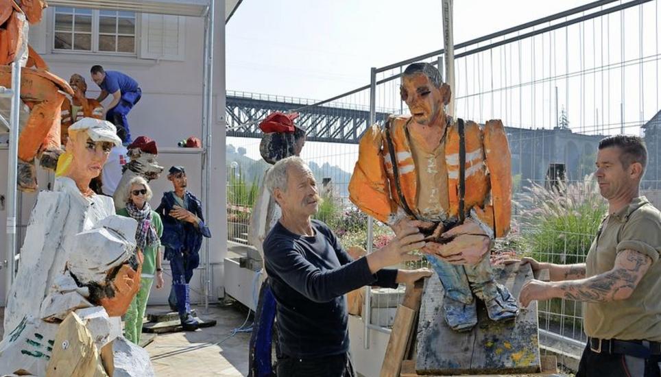 Künstler Peter Leisinger (l.) platziert gemeinsam mit Roger Jelk eine aus Holz geschnitzte Bauarbeiterfigur vor der ehemaligen «Fischerzunft». Bild Pascal Schmidlin