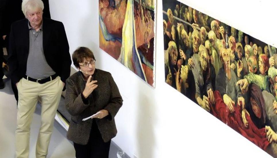 Tina Grütter (vorn) bespricht in der Galerie Mera Bruno Ritters (links) Werk «Das Boot», das Menschen in lebensbedrohender Enge zeigt.Bild Eric Bührer