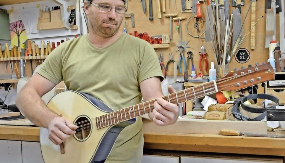 Peter Demmerle mit der «Blue-zuki» – so nennt er seine selbst gebaute, blau lackierte Bouzouki. Bild: Luca Miozzari