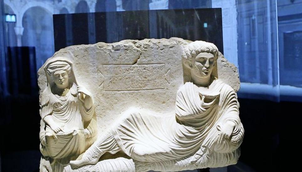 Die Ausstellung in Paris zeigt unter anderem diese Grabeskunst aus dem dritten Jahrhundert. Im Hintergrund sind die Ruinen von Palmyra projiziert. Bild: Key