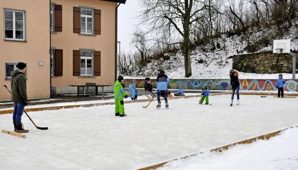 Einige Kinder und Eltern vergnügen sich auf dem Eisfeld beim Schulhaus Dörflingen. Das Feld kommt bei den Benützern gut an. «Die Kinder finden das Feld lässig», sagt Andreas Rechsteiner, der das Feld seit ein paar Jahren immer wieder aufbaut. Bild: zvg