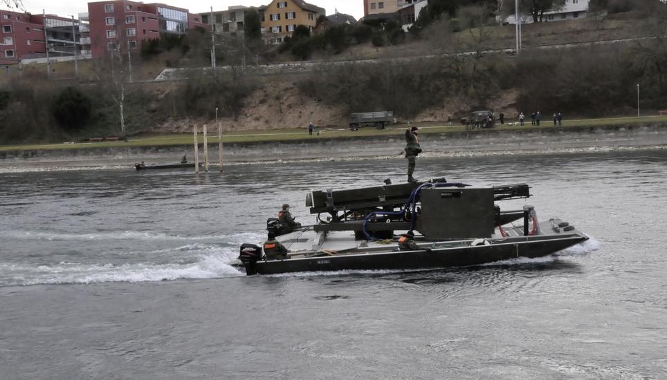 Die Pontoniere sind mit der Rammbühne auf dem Rhein unterwegs. Im Hintergrund sind die neu eingesetzten Pfähle zu sehen. Bild: Mark Gasser