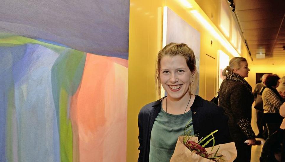 Die Künstlerin Anna Peterer steht in der oberen Etage des Kantonalbank-Hauptsitzes neben dem Bild, das die Einladung zur Ausstellung ziert. Dort war die obere Fläche noch rot, jetzt hat sie diese blau übermalt. Bild: Selwyn Hoffmann