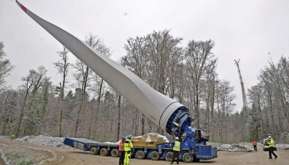 Kurz vor dem Bauplatz auf Verenafohren wird gewendet und das Rotorblatt abgesenkt; rechts hinten einer der drei Masten des künftigen Windparks am Randen. Bild: Theo Kübler
