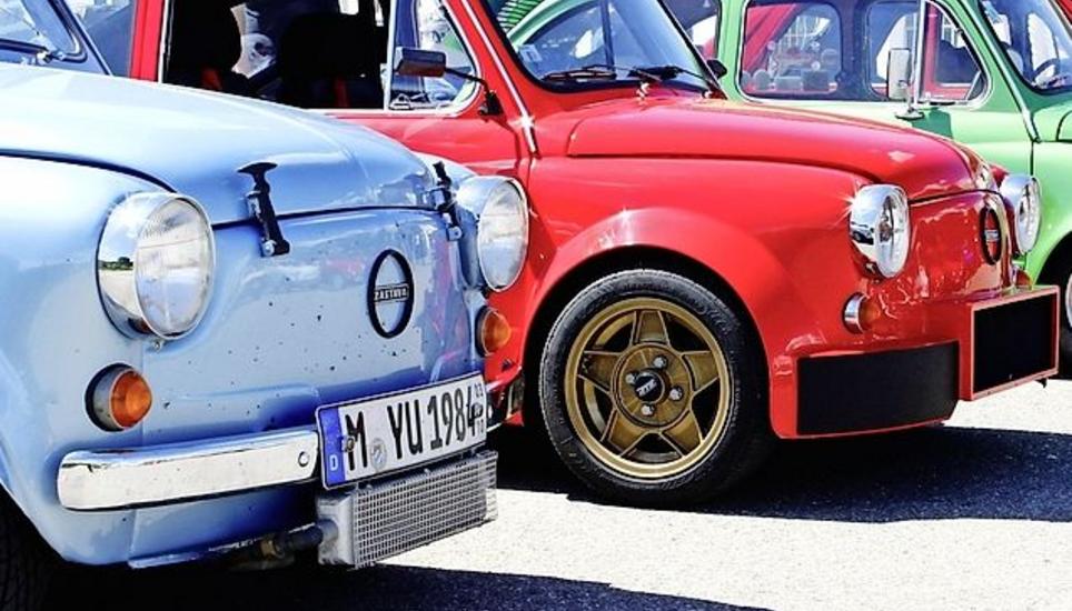 Die legendären, bunten Autos der Marken Zastava und Fiat aufgestellt in Reih und Glied. Bild: Maximilian Wiggenhauser