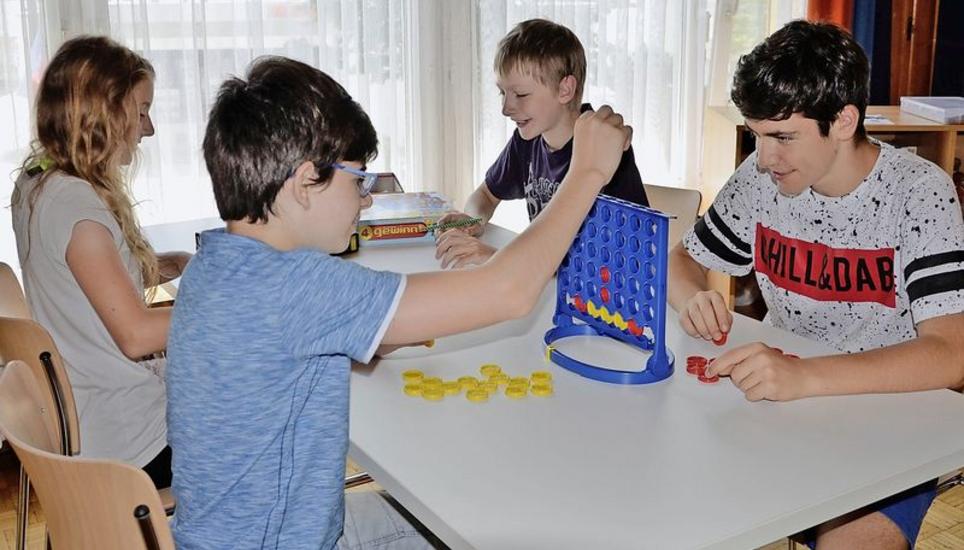 Nach dem Mittagessen werden Spiele gespielt, bevor man sich auf den Weg zur Schule oder nach Hause macht. Von links nach rechts: Melissa Siegrist (14 Jahre), Nicola Pettikofer (13), Björn Kittlas (12) und Florian Sadiko (14). Bild: Corina Mühle