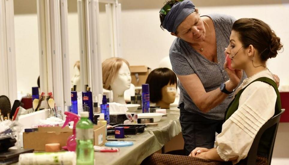 In der Maske: Die Visagistin Johanita Mutter pudert das Gesicht der Chorsängerin Jeannine Allieri. Der Backstage-Bereich ist privat und dient als Oase der Ruhe.