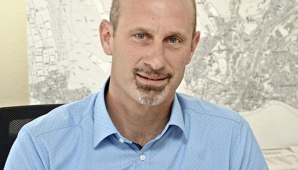 Beat Knecht sitzt in seinem Büro vor der Stadtkarte, auf welcher die städtischen Schulen und Kindergärten abgebildet sind. Bild: Tito Valchera