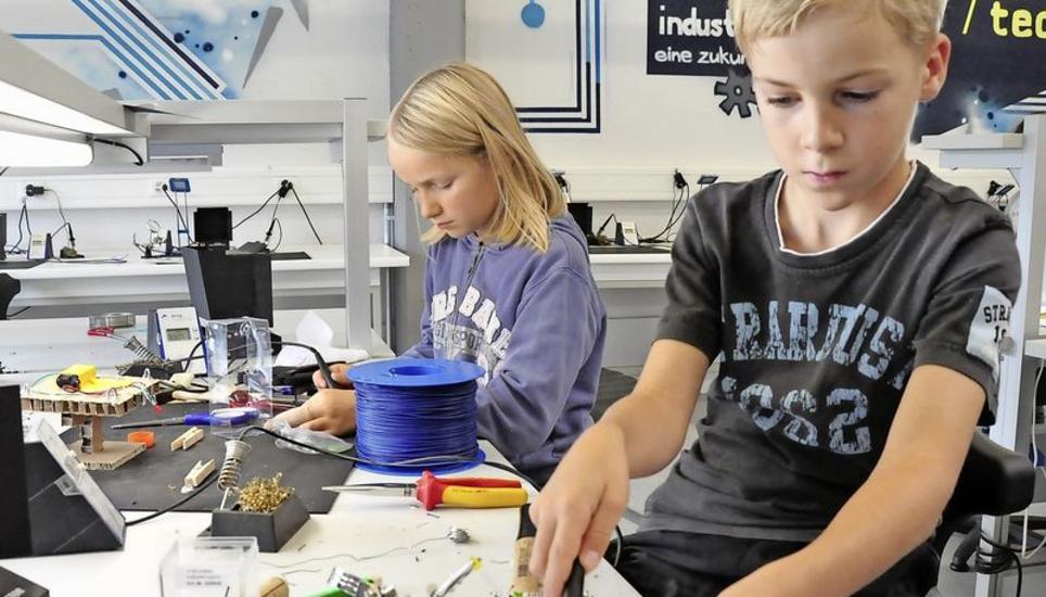 Geschickt sorgen die Geschwister Jonas und Andrina Ernst während des Tüftelcamps mit dem Lötkolben für die nötigen elektronischen Kontakte. Bild: Christoph Merki