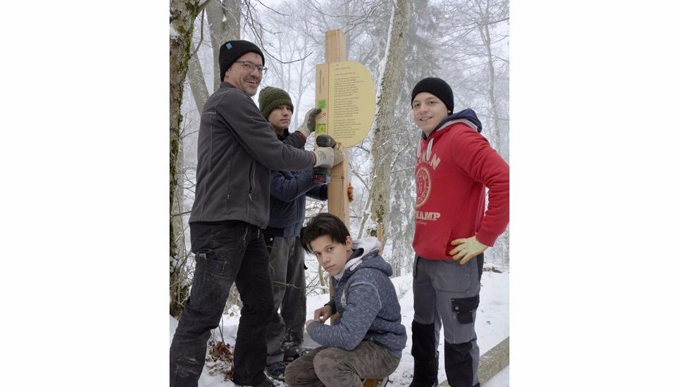 Lehrer Urs Sonderer mit den Schülern Oguzhan Yanlar, Rami Makkieh und Luan Pessoa (von links) bringen auf dem Schleitheimer Schlossranden einen neuen Pfosten an. Bild: sba