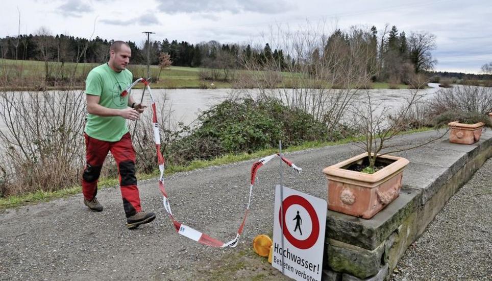 Kurz nach dem Mittag flossen bei Gütighausen (Bild) und Andelfingen nur noch rund 400 Kubikmeter Wasser pro Sekunde die Thur hinab. Feuerwehrmann Marcel Frauenfelder kann daher die Absperrung wieder wegräumen. Bild Mark Gasser