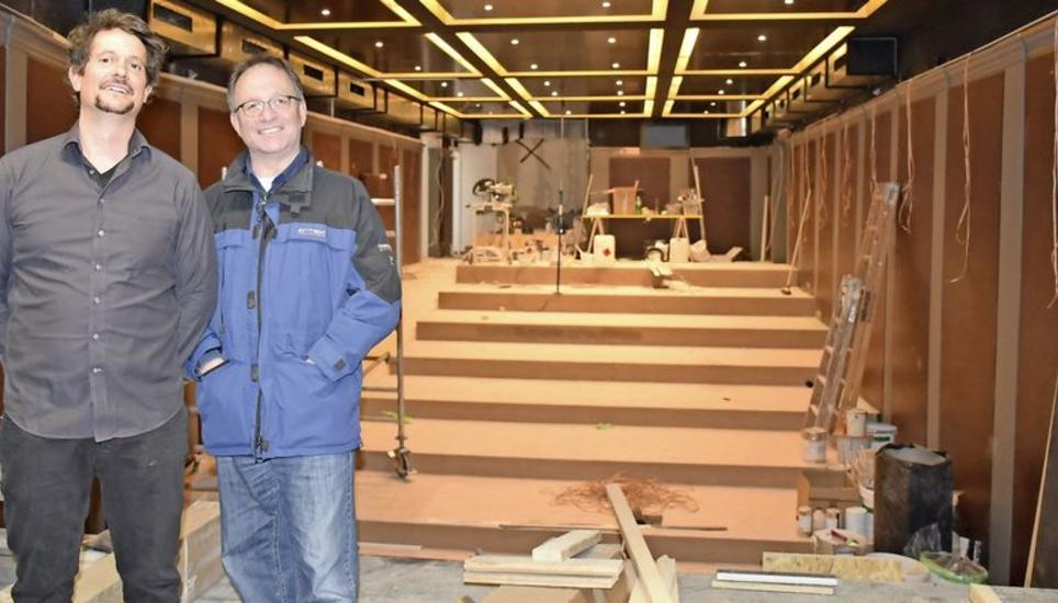 Der Kino- und Theatersaal hinter Urs Hofer und Frieder Tramer erstrahlt durch den goldenen Anstrich bereits glamourös. Die roten Sessel fehlen noch. Bild: Darina Schweizer