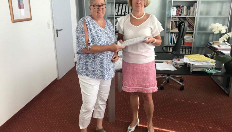 Andrea Schmid (links) übergibt Ira Sattler (rechts) die Unterschriften. Bild: RM