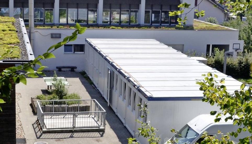 Zwei Klassen sind vorübergehend in den Schulcontainer gezügelt, der auf dem Schulareal steht. Bild: Luc Müller