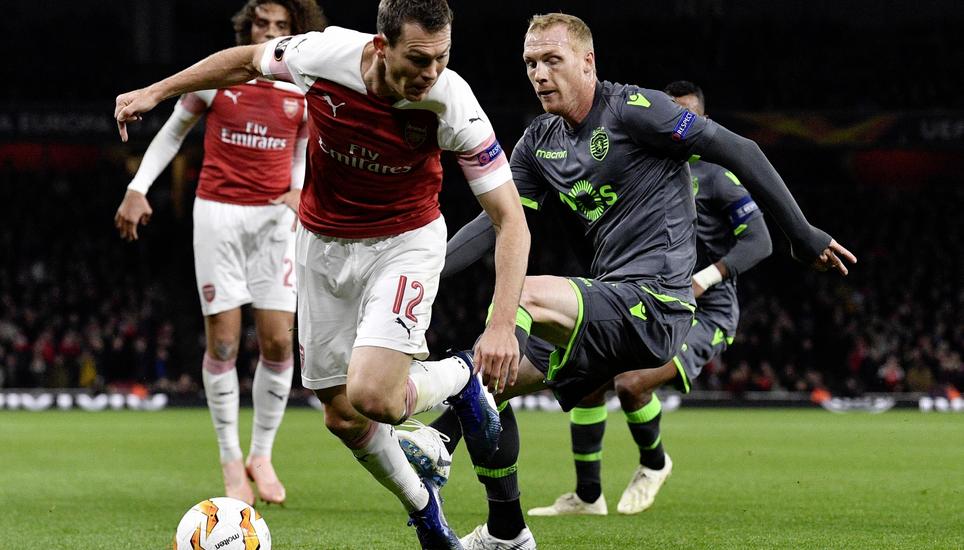 Stephan Lichtsteiner von Arsenal wird hier im Europa-League-Spiel von Jeremy Mathieu (Sporting Lissabon) gefoult. Bild: Key