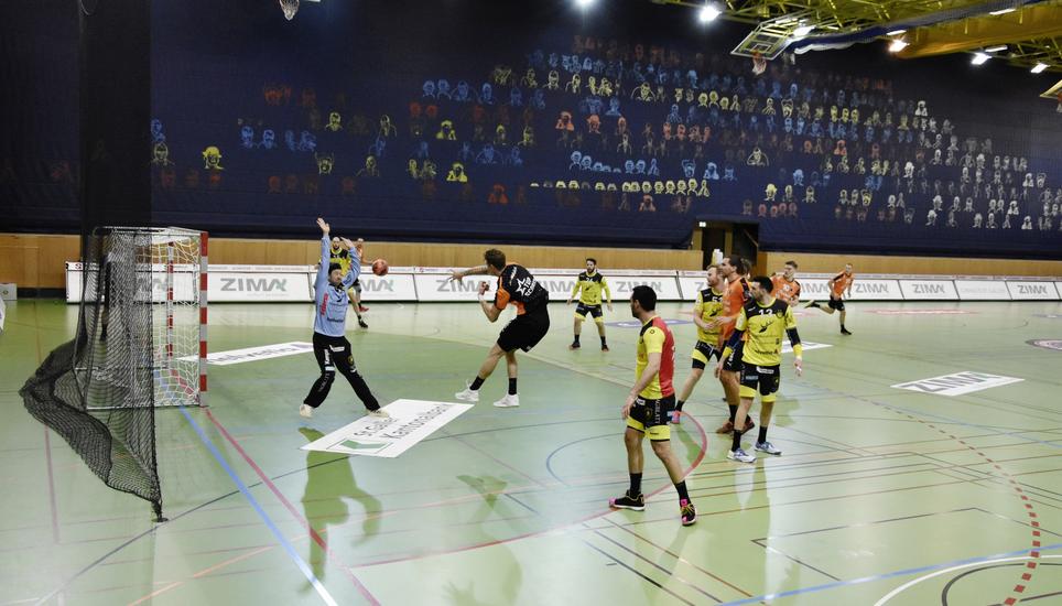 Vor der Geisterkulisse in der Kreuzbleichehalle setzt sich hier der 13-fache Torschütze der Kadetten, Sebastian Frimmel, gegen den Otmar-Goalie Aurel Bringolf durch. Bild: Pascal Oesch