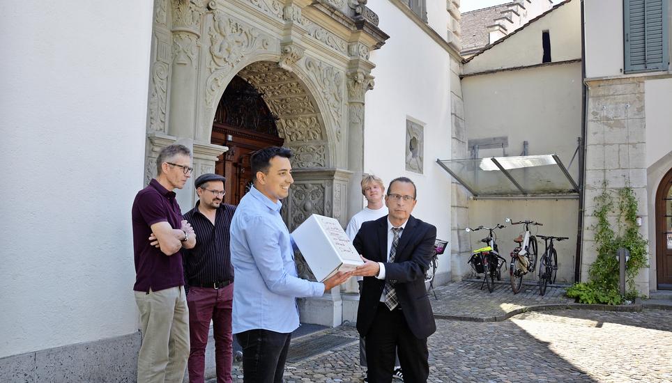 Übergabe an den stellvertretenden Staatsschreiber Christian Ritzmann: Matthias Freivogel, Mathias Frick, Patrick Portmann und Finn Van Belle (v. l.). Bild: lbb