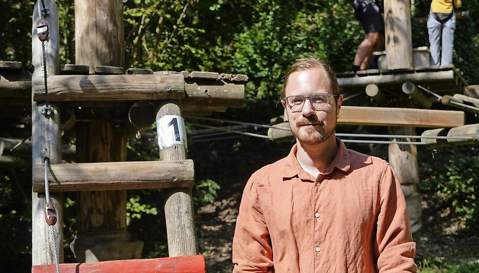 Tim Obrist vor dem Kinderpark, in dem bereits Holzstämme stehen. Bild: Shania Eberhard