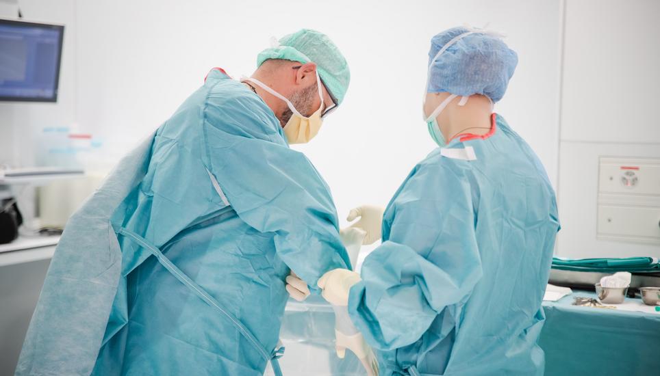 Haarnetz, Mundschutz und das blaue OP-Kleid sind Pflicht.