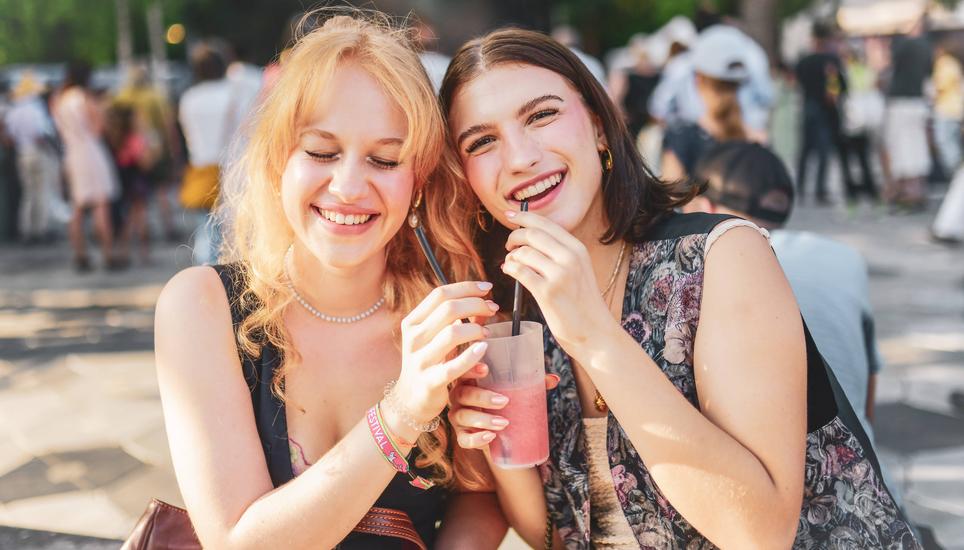 Die Freundinnen Mara, links, und Nora teilen sich ihren Drink.