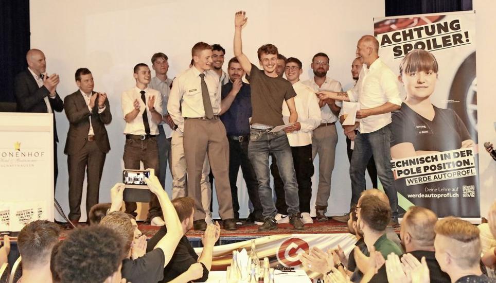 Severin Kramer (winkend) und Roland Oberhänsli (links daneben) werden als beste Mechatroniker des Jahrgangs geehrt. Bild: Dominic Caviezel