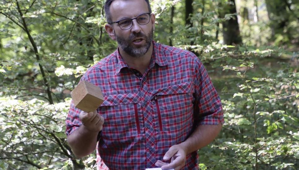 Urs Buchli zeigt, dass im Forstrevier pro Sekunde Holz von der Grösse dieses Klotzes nachwächst. Bild: Roland Müller
