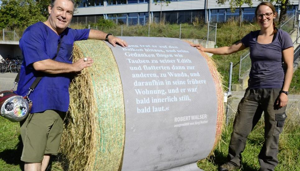 Beat Toniolo präsentiert zusammen mit Julia Mettler einen dekorierten Strohballen seiner Kunstinstallation LiteraTOUR-Weg. Bild: Thomas Martens