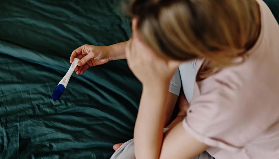 Eine Frau hält einen negativen Schwangerschaftstest in den Händen. Symbolbild: Getty