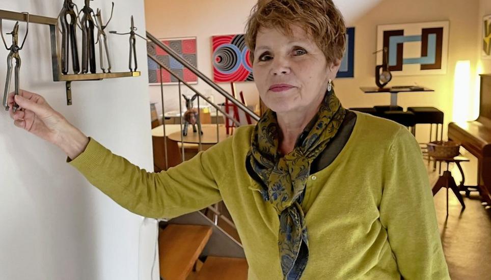 Verena Bügler weist auf das filigrane Kunstwerk im Eingangsbereich der Kunstschür von Turi Albert. Er hat alte Rebscheren in eine lustige Figurenparade verwandelt – eine Anspielung an ihre Arbeit im Weinberg. Bild: Gudrun Trautmann