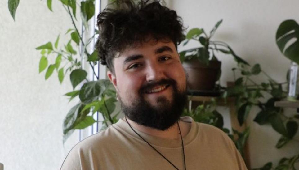 Samuel Bachmann in seinem Wohnzimmer. Links einige der Chilistecklinge. Bild: Remo Wenk