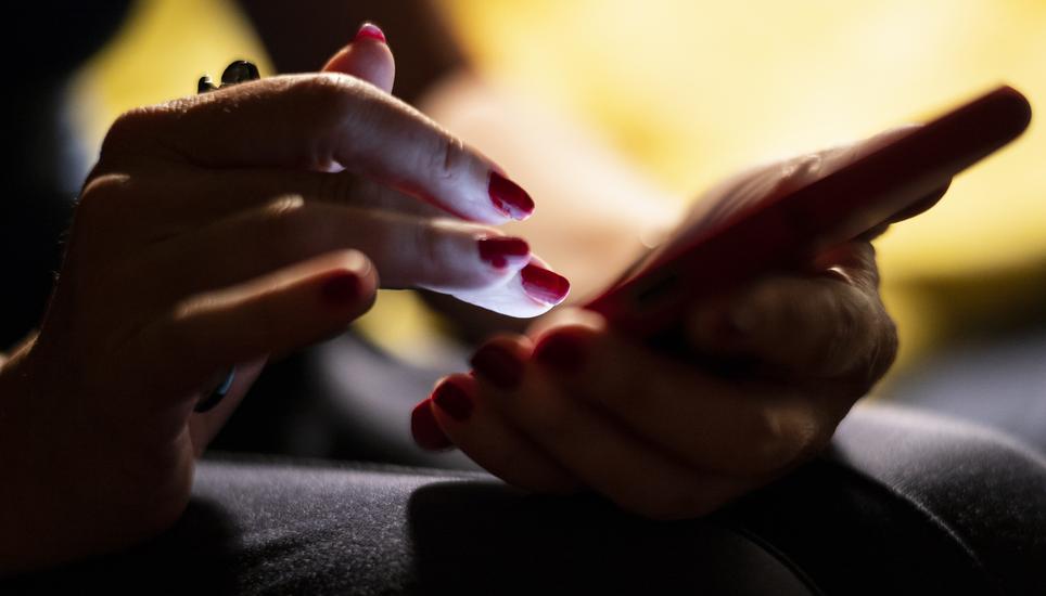 Derzeit erhalten Schweizerinnen und Schweizer wieder massenhaft Phishing-Textnachrichten aufs Handy. Symbolbild: Key Eine Frau bedient ihr Smartphone, am Mittwoch, 30. Juni 2021 in Bern. (KEYSTONE/Alessandro della Valle)