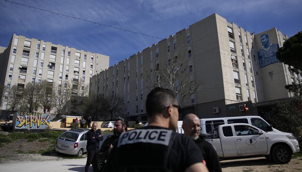 Police officers secure La Castellane district during a visit focusing on security and the fight against drug trafficking by French President Emmanuel Macron, Tuesday, March 19, 2024 in Marseille, southern France. (AP Photo/Christophe Ena)