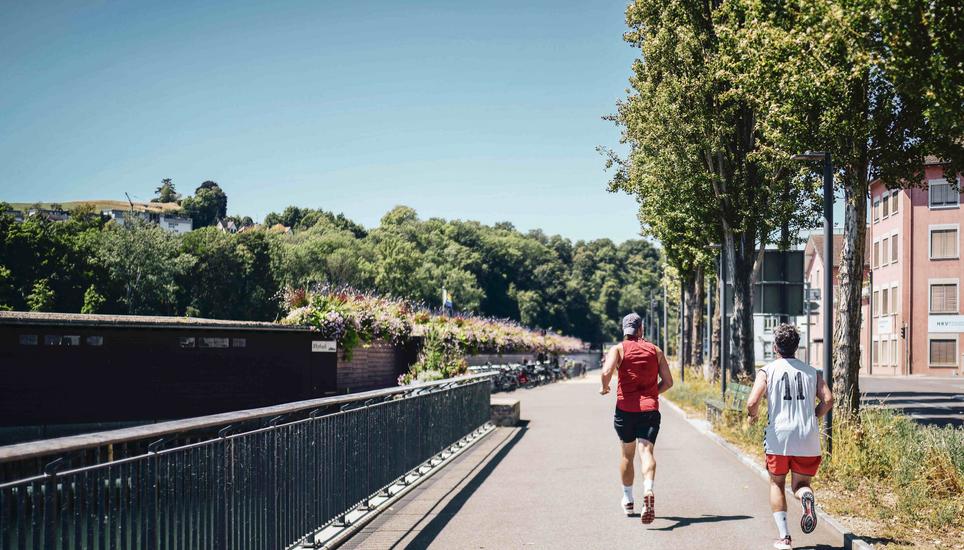 Jogger laufen dem Rhein und der Rhybadi entlang, fotografiert zum Thema Sumer in the city, Sommer in der heissen Altstadt, am Mittwoch, 03. August, 2022. (Melanie Duchene / Schaffhauser Nachrichten)