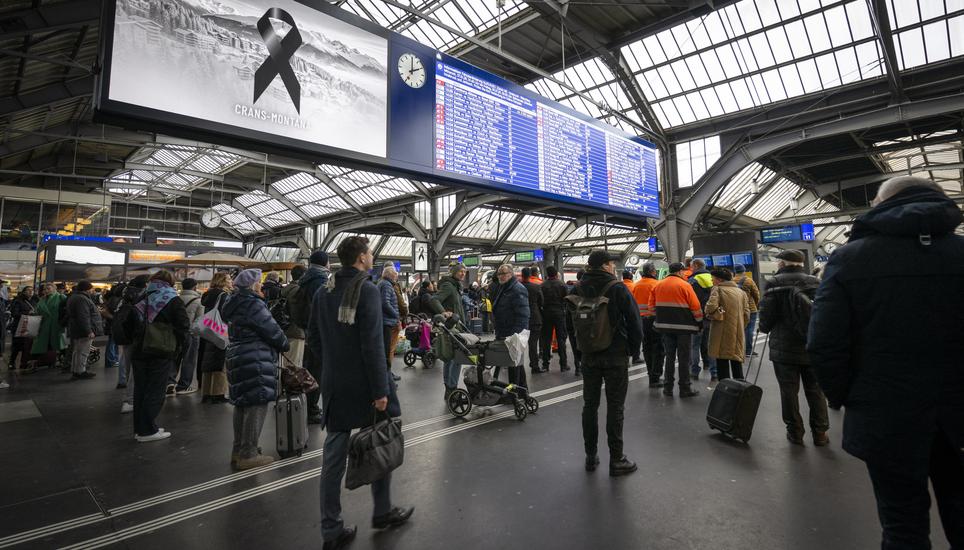 People observe a minute of silence in memory of the victims during the national day of mourning following the deadly fire at the "Le Constellation" bar in Crans-Montana at the main station in Zurich, Switzerland, Friday, January 9, 2026. 40 people mostly 