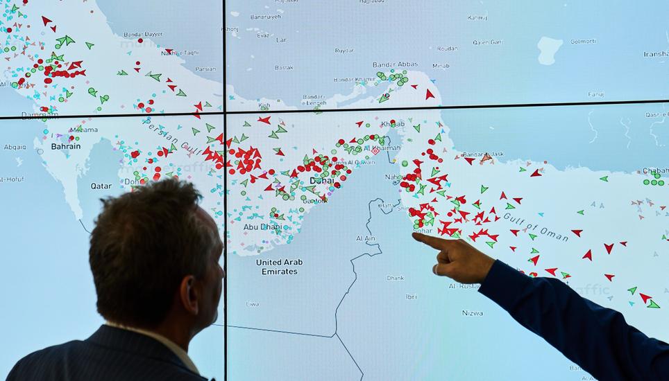 Hapag-Lloyd employees monitor the status of cargo ships in the Strait of Hormuz on a screen, in Hamburg, Germany, Wednesday, April 15, 2026. (AP Photo/Ebrahim Noroozi)