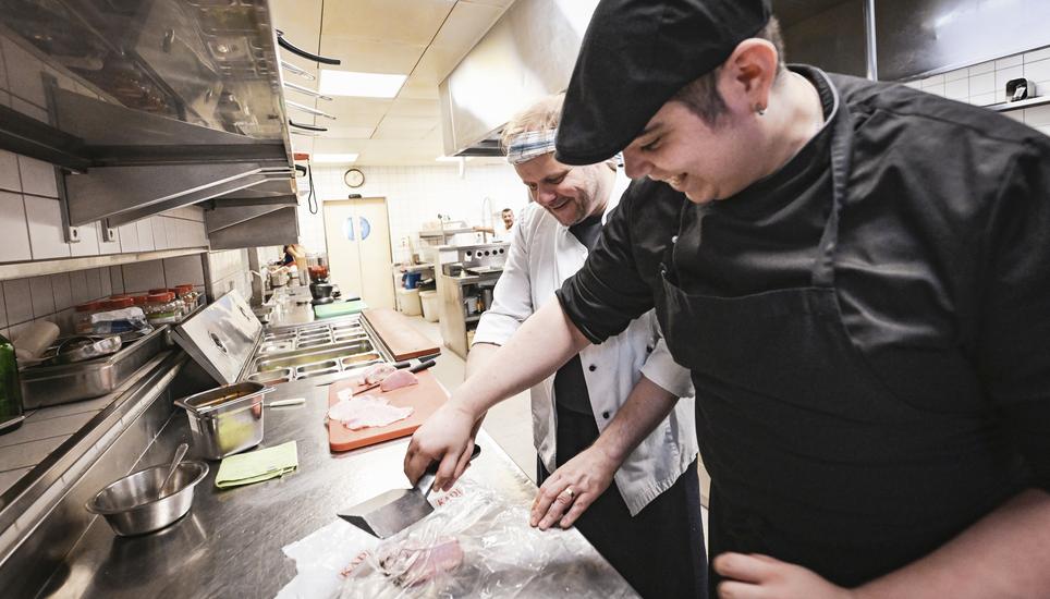 «Più forte, Marco, più forte!» – Souschef Mariano Niglia zeigt, wie das Dünnklopfen des Schweineschnitzels geht. (Melanie Duchene / Schaffhauser Nachrichten) SN Redaktor Mark Liebenberg als Koch im Restaurant Falken , am Mittwoch, 17 Juli 2024. (Melanie Duchene / Schaffhauser Nachrichten)