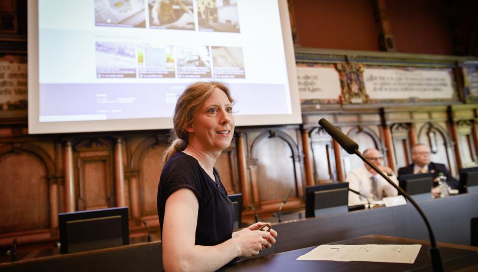 Karola Brüggemann vom Staatsarchiv erklärt im Kantonsratssaal den Zugang zum digitalen Lesesaal. Im Hintergrund Staatsschreiber Stefan Bilger und Staatsarchivar Roland E. Hofer. Bild: Melanie Duchene Medienorientierung Digitaler Lesesaal klio.sh.ch mit Karola Brï¿ï¾¼ggemann, Stefan Bigler und Roland Hofer, am Montag, 23. Juni 2025. (Melanie Duchene / Schaffhauser Nachricht