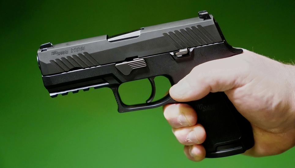A Sig Sauer P320 handgun is held by a Maine gun shop owner, Tuesday, June 17, 2025. (AP Photo/Robert F. Bukaty)