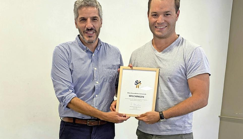 Projektleiter Simon Stocker (l.) überreicht Gemeinderat Benjamin Albiez die Auszeichnung für die Gemeinde Wilchingen zur erfolgreichen Teilnahme am Programm «Altersfreundliches Schaffhausen». Bild: zVg