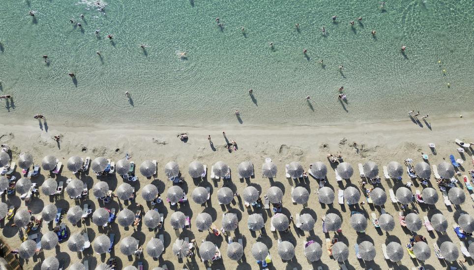 People enjoy the sea in Avlaki beach about 42 kilometers (26 miles) east of Athens, Greece, Wednesday, Aug. 19, 2025. (AP Photo/Thanassis Stavrakis)