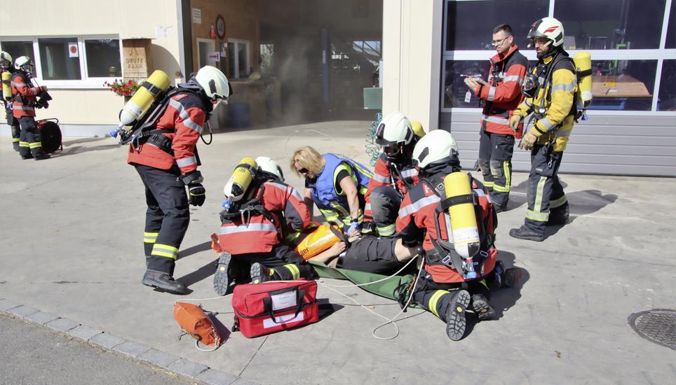 Eine unter Atemschutz geborgene verletzte Person erhält eine Erstbetreuung.