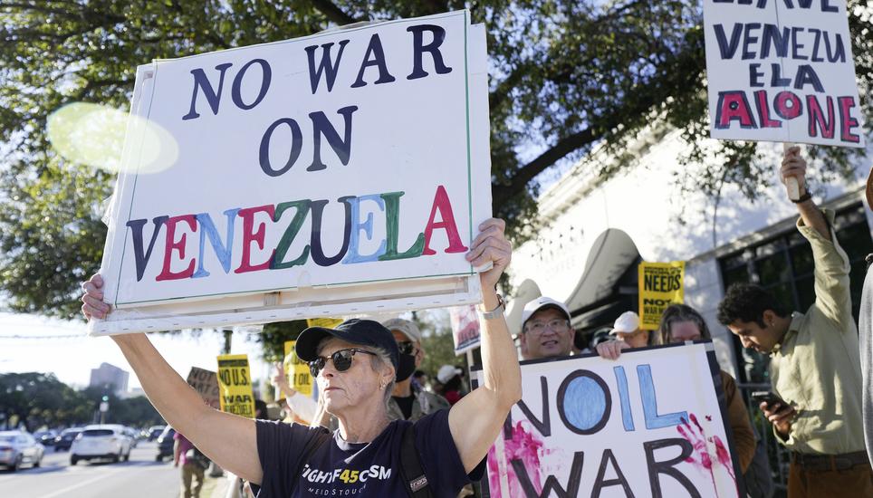 Patty Harland holds up a sign during a rally protesting the United States' involvement in Venezuela, Sunday, Jan. 4, 2026, in Houston. (Elizabeth Conley/Houston Chronicle via AP)