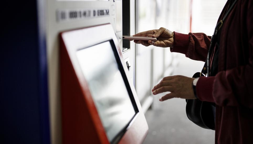 Eine Frau bezahlt an einem SBB Billettautomaten mit ihrem Smartphone, fotografiert am Montag, 1. Juli 2024 am Bahnhof Oerlikon in Zuerich. (KEYSTONE/Christian Beutler)