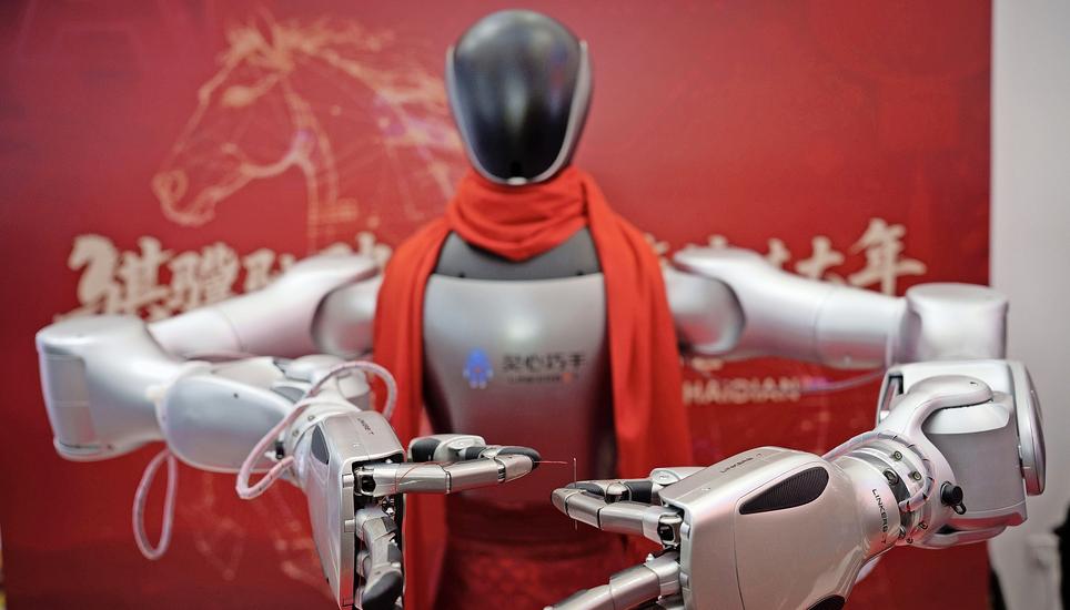 A humanoid robot wearing a festive red scarf demonstrates hand movements during a Lunar New Year tech temple fair in Beijing, Thursday, Feb. 19, 2026. (AP Photo/Vincent Thian)